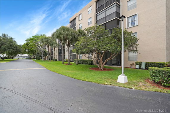 Front view of a multi-story residential building with screened balconies.