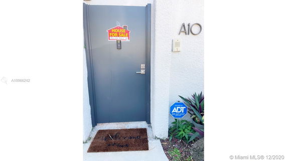 Front view of a house door with a 'House for Sale' sign and security sign.