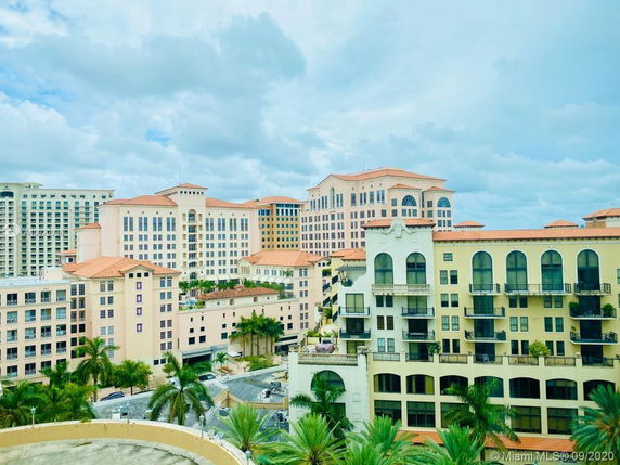 View of multiple multi-story buildings with balconies and arched windows.
