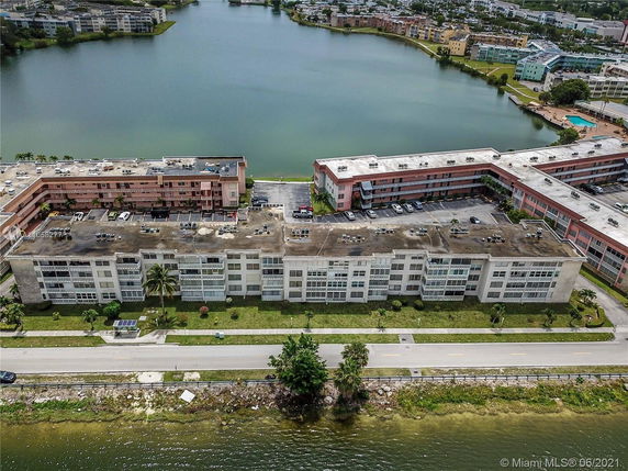 Aerial view of a multi-story residential building near a lake