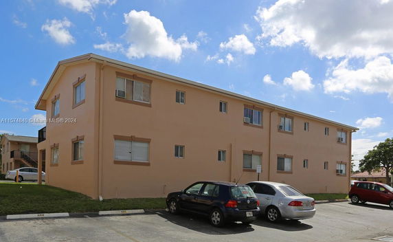 Front view of a two-story apartment building with parking area.