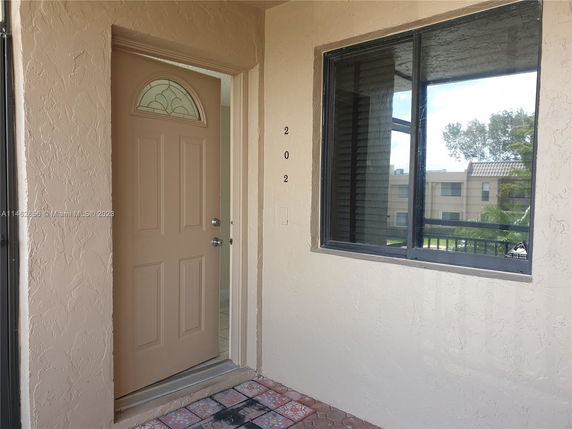 Front view of a residential entrance with a brown door and window.