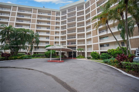 Front view of a multi-story residential building with a canopy-covered entrance.