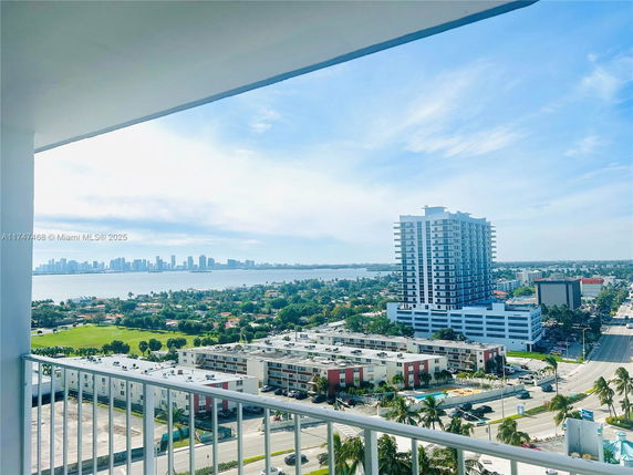 Panoramic view from a balcony overlooking a cityscape and waterfront.