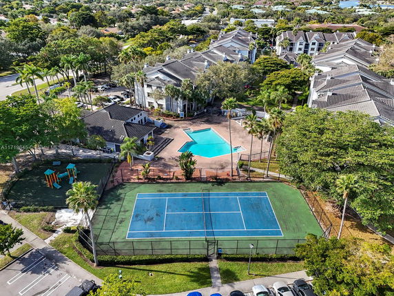 Aerial view of a residential complex with tennis court and swimming pool.