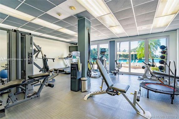 Indoor gym area with various fitness equipment and large windows.