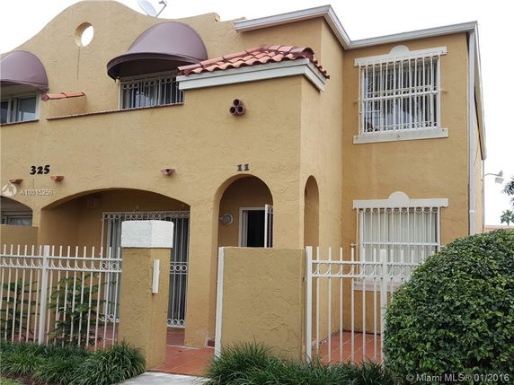 Front view of a two-story house with arched windows and a gated entrance.
