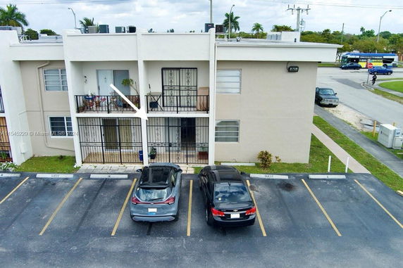 Front view of a two-story building with balconies and parking area.