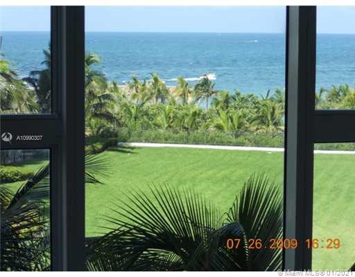 View of the ocean and greenery seen through windows.
