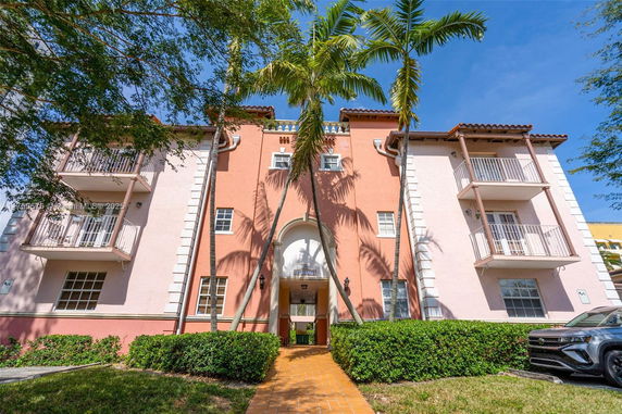 Front view of a multi-story building with balconies and a central entrance
