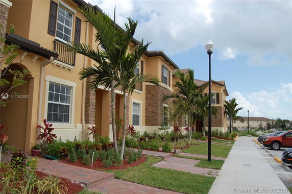 Front view of a two-story townhouse with stone and stucco facade.