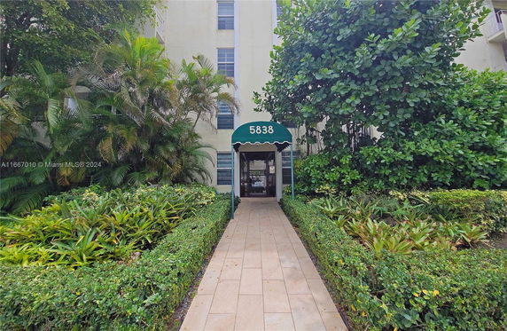 Front view of a multi-story building with a green canopy entrance.