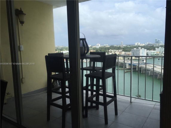 View from a high-rise balcony overlooking water and distant cityscape.