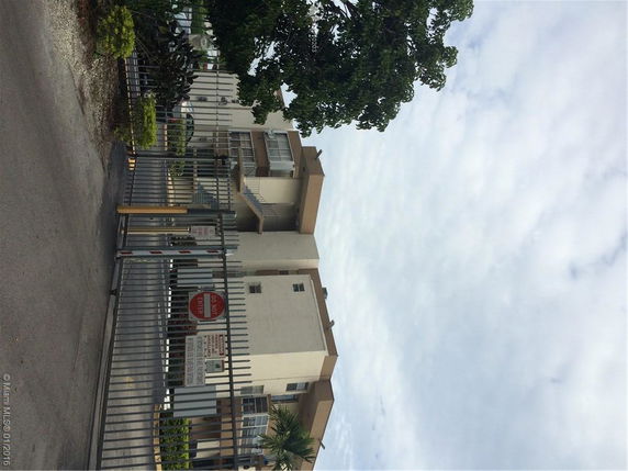 Front view of a multi-story building with a gated entrance.