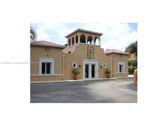Front view of a Mediterranean-style building with arched windows and terracotta roof.