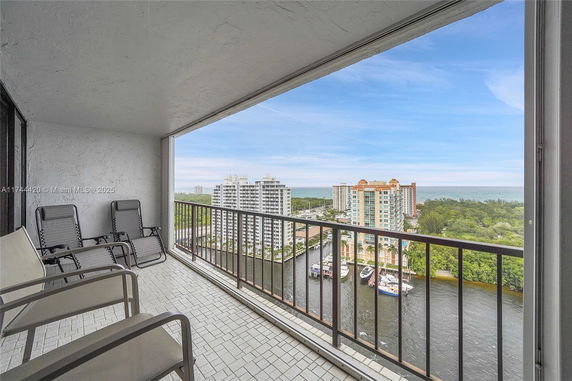 Panoramic view from a balcony overlooking a waterway with buildings and greenery.