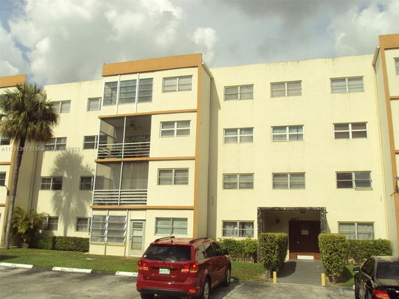 Front view of a four-story apartment building with balconies.