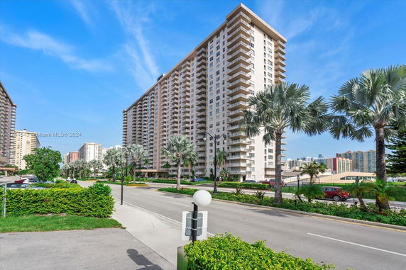 Front view of a high-rise residential building with multiple balconies.