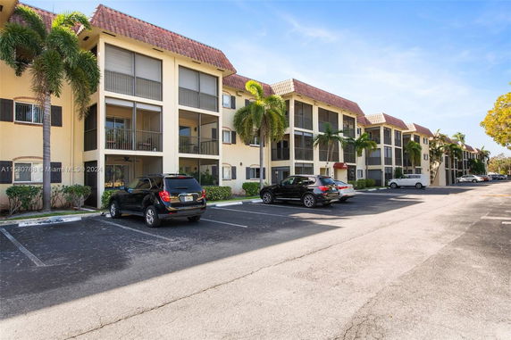 Outdoor parking area in front of a multi-story residential building.