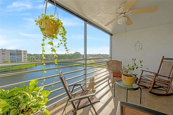View from a balcony with seating and potted plants overlooking a body of water.