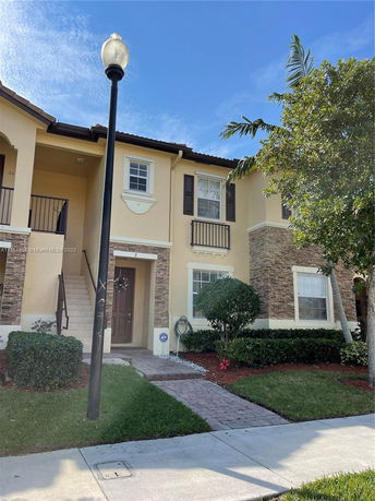 Front view of a two-story townhouse with stone and stucco exterior.