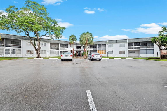 Front view of a two-story apartment building with parking area.