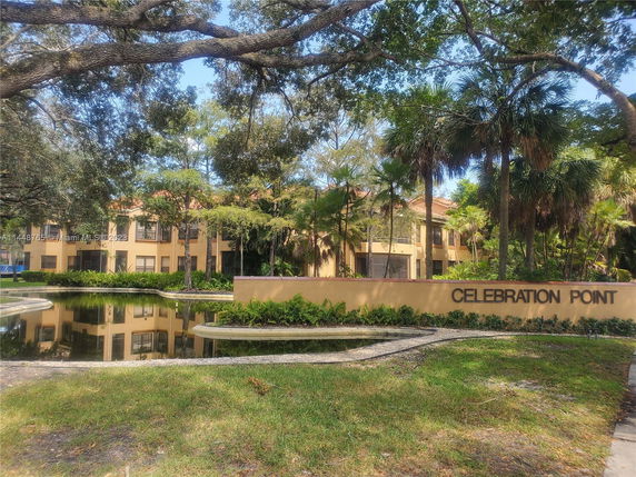 Front view of a two-story building with large windows and surrounding greenery.