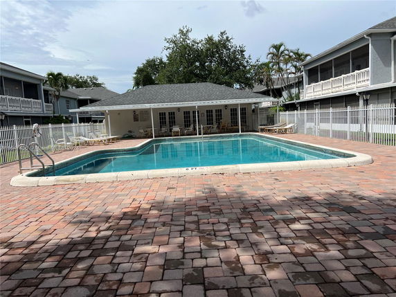 Outdoor swimming pool surrounded by buildings with balconies.