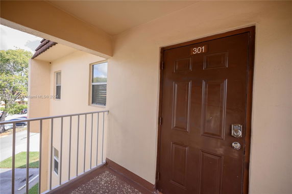 Entrance view with brown door marked 301 and railing.