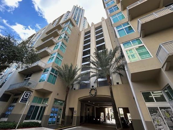 Front view of a multi-story modern building with large windows and balconies.