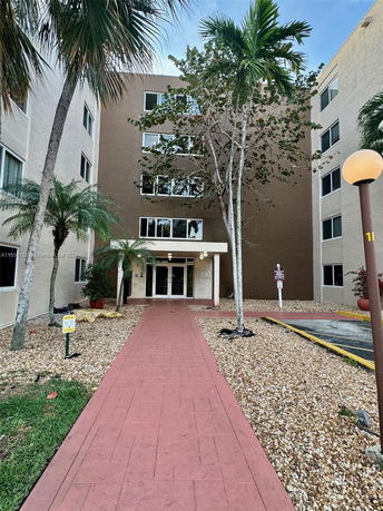 Front view of a multi-story building with an entrance pathway.