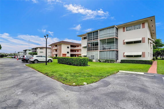 Front view of a multi-story building with enclosed balconies.