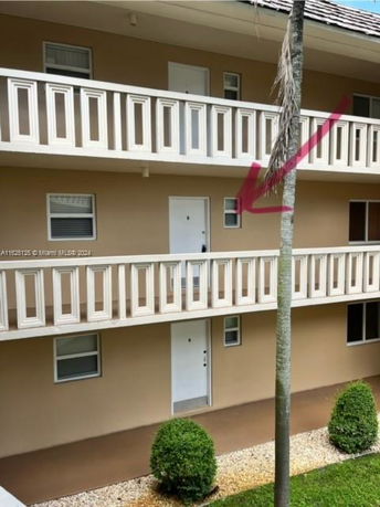 Front view of a multi-story building with balconies and doors visible.