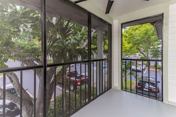 View from a balcony showing a parking area and trees.