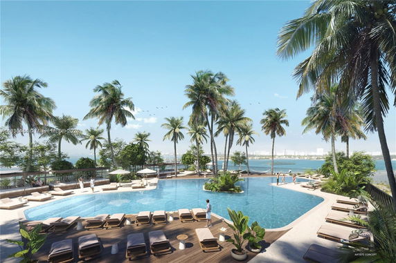 View of a swimming pool area surrounded by palm trees and overlooking a body of water.