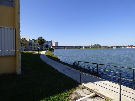 View of a lake with nearby residential buildings.