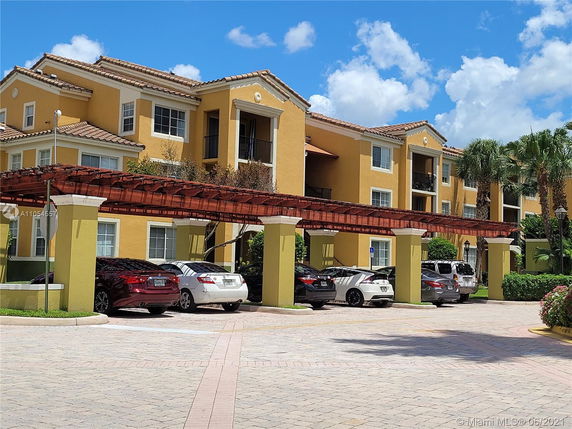 Front view of a multi-story building with covered parking area.