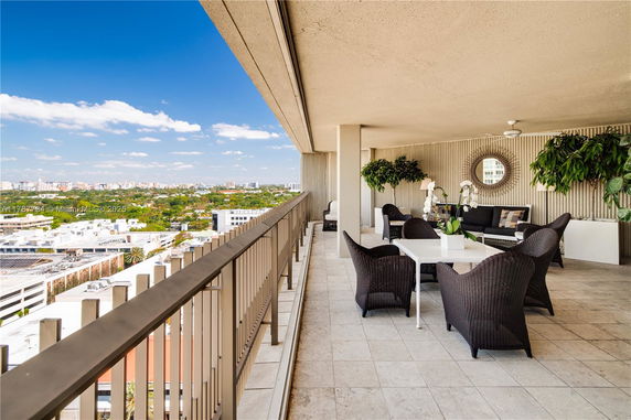Spacious balcony with outdoor seating overlooking cityscape.