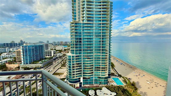 High-rise building with a beachfront view and surrounding skyline.