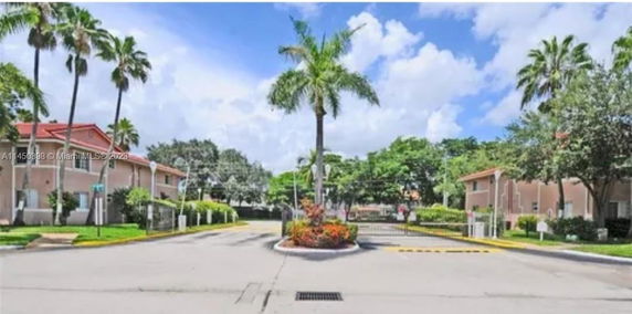 Front view of a residential area with multiple buildings and palm trees.