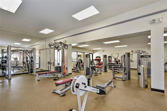 Indoor gym area with various exercise equipment and machines.