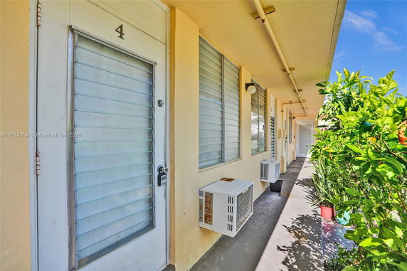 Exterior view of a building corridor with doors and windows.