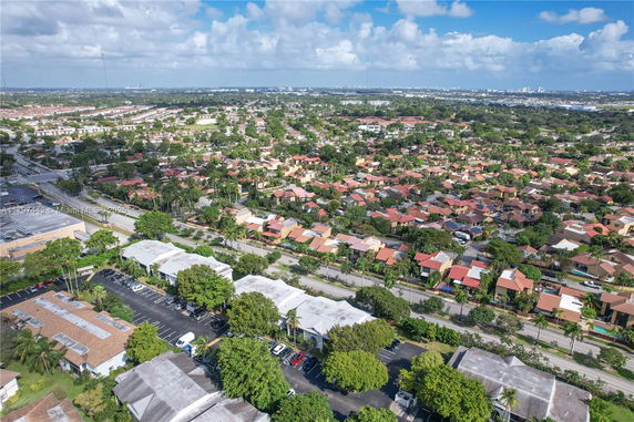 Aerial wide-angle view of residential area with houses and greenery.