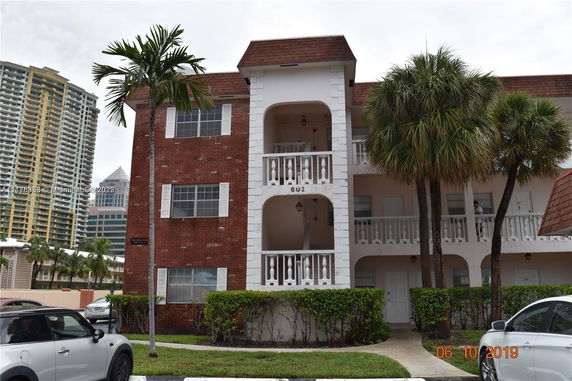 Front view of a multi-story building with red brick and white accents.