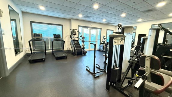Indoor gym area with exercise equipment including treadmills and weight machines.