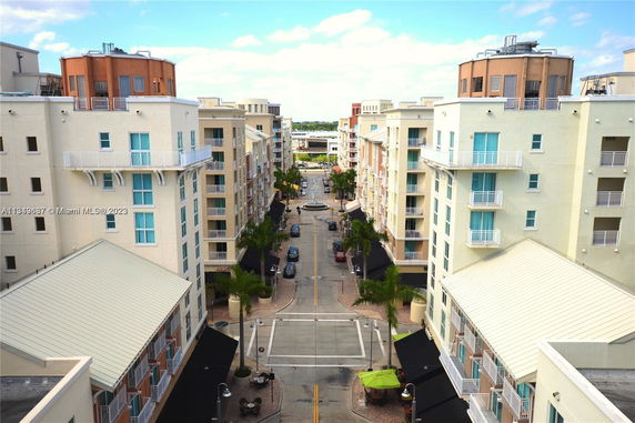 Aerial view of a street flanked by multi-story residential buildings with balconies.