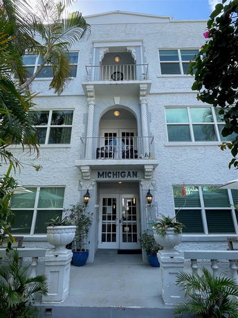 Front view of a multi-story building with balconies and decorative columns.