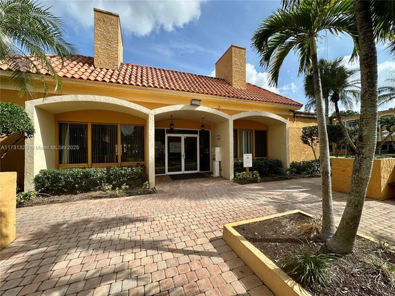 Front view of a building with a tiled roof and arched entrance.