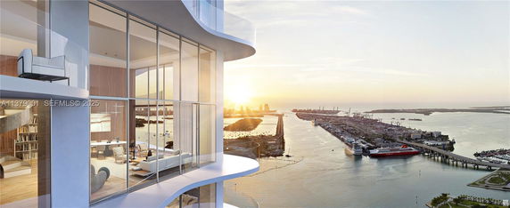 Panoramic view of a high-rise building with glass windows overlooking a waterfront and cityscape at sunset.