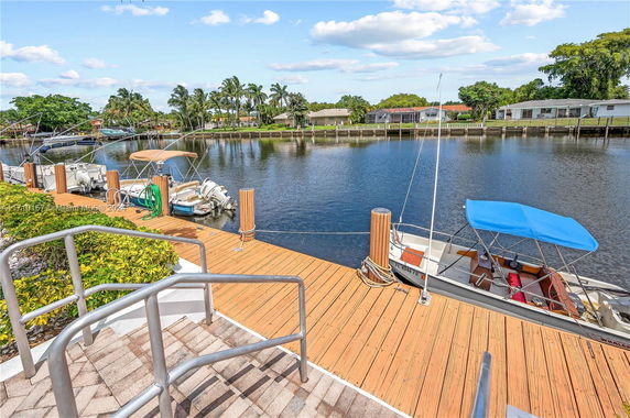 View of a waterfront area with boats docked along a wooden deck.